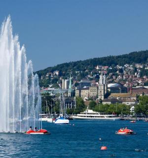 vodní fontána uprostřed jezera s městem