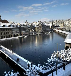 Pohled na město se zasněženými budovami a řekou