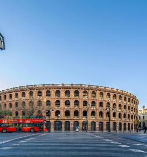 一辆红色双层巴士停在一栋建筑物前