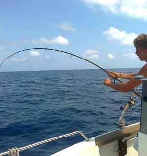 a man fishing on a boat in the ocean