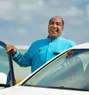 一名男子站在一辆汽车旁边