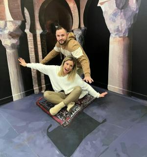a man and a woman sitting on a snowboard