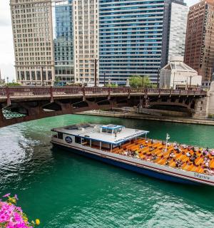 loď plující po řece pod mostem