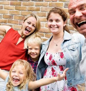 a family posing for a picture in front of a brick wall