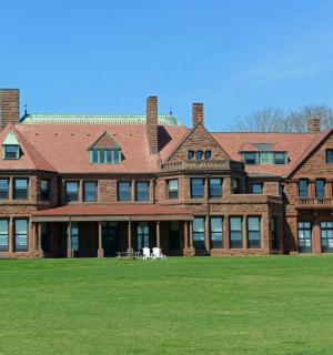 a large brick building with a grass field in front