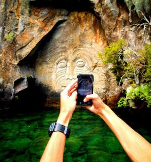 a person taking a picture of a rock face with a cell phone