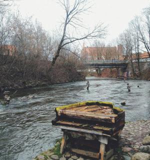 a piano sitting in the middle of a river