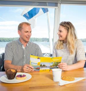 karl og kona sitja við borð og borða mat