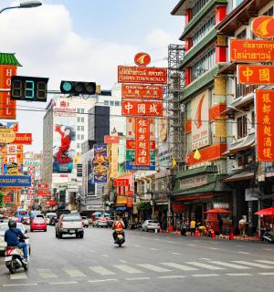 rušná městská ulice s auty, motocykly a cedulemi