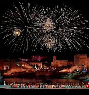 a group of people standing in front of a city with fireworks