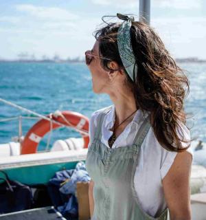 一名女子站在水中的船上