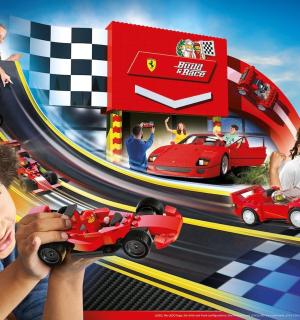 mladý chlapec si hraje s autíčkem na závodní dráze