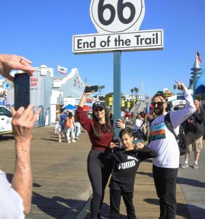 一群人站在木板路上,手里拿着一块牌子