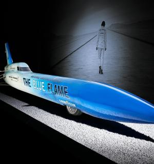 a blue and white boat sitting in a dark room