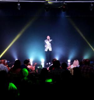 一名男子站在舞台上,面对着一群人