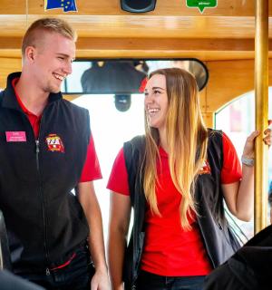 a man and a woman standing on a bus