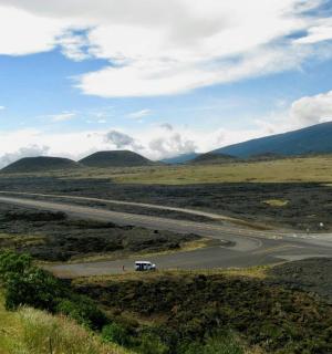 田野中间的一条路，路边有一辆货车