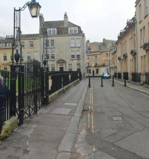 一名女子站在街道围栏旁