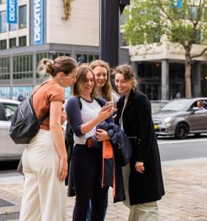 eine Gruppe von drei Frauen steht auf einer Stadtstraße