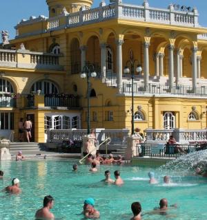 a group of people in a pool in front of a building