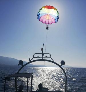 一只热气球飞过水中的一艘船