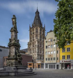 a statue in front of a building with a tower