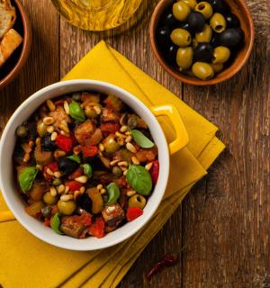 miska jídla na dřevěném stole s chlebem