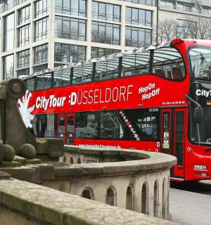 a red double decker bus driving down a street