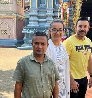 一名女子和两名男子站在一栋建筑物前