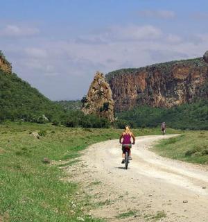 两个人骑着自行车沿着土路行驶