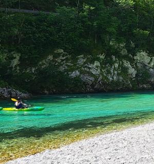 tři lidé v kajacích ve vodě na pláži