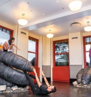a woman is sitting on top of a sculpture in a building
