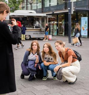 一名女子正在给一群女孩拍照