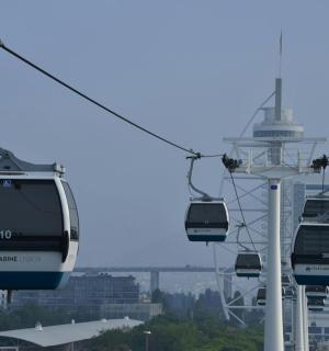 three gondolas on a ski lift in a city