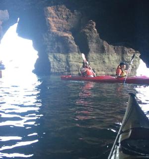 زوجان من الأشخاص في قارب كاياك في كهف