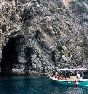 eine Gruppe von Menschen auf einem Boot vor einer Höhle