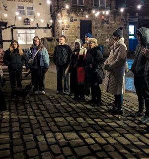 a group of people standing around in the street at night
