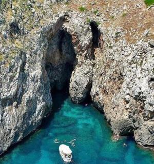 a boat in a cave in the middle of a cliff