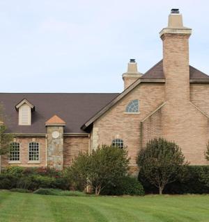 Velký cihlový dům s komínem na trávníku