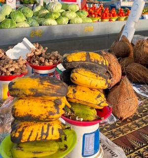 桌子上的一堆香蕉和其他水果和蔬菜