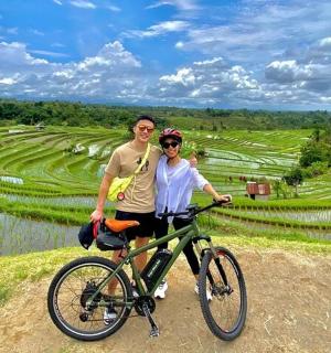 muž a žena stojící vedle kola