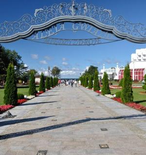 ทางเดินในสวนสาธารณะที่มีซุ้มประตูสีน้ำเงินและสีขาว