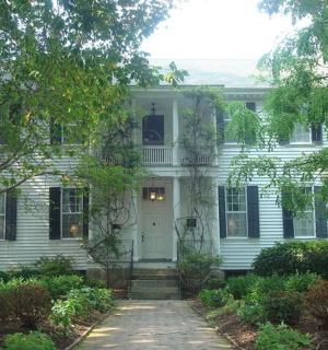 ein weißes Haus mit einer weißen Tür und Bäumen