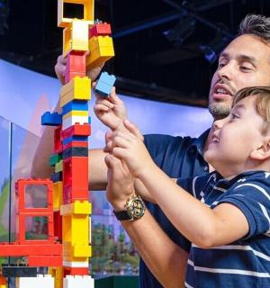 一名男子和一名小男孩玩乐高塔