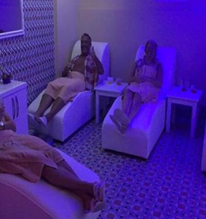 three women sitting in beds in a room with purple lighting