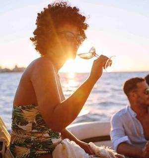 a woman drinking a glass of wine on a boat