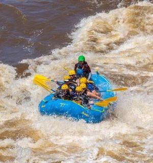 a group of people in a blue raft in the water