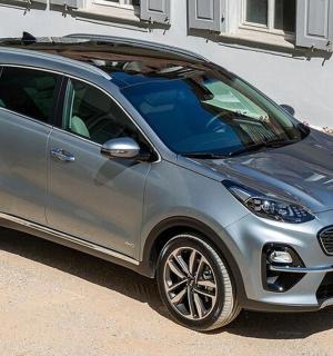 a silver smart car parked next to a building