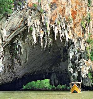 żółta łódź na wodzie przed jaskinią