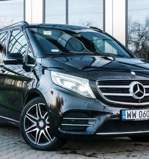 一辆黑色汽车停在一栋建筑物前